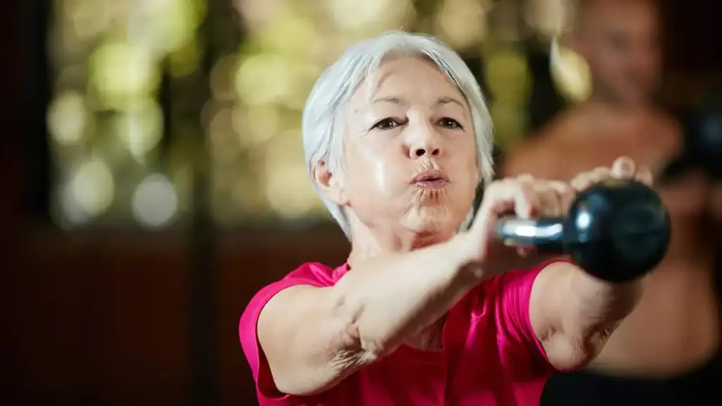 Toning Arms After 60: Empowering Womens Fitness Through Effective Weight Training 1 Older woman doing weight training Rickmansworth to help her strength and longevity