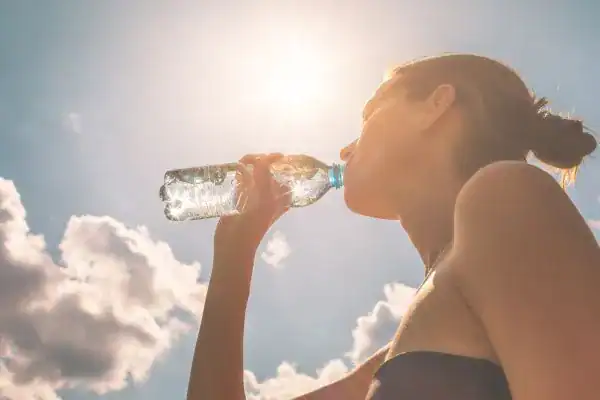 Hydration: The Secret Ingredient for a Toned Stomach and Enhanced Fitness 3 Image of woman drinking water to hydrate Rickmansworth after run.