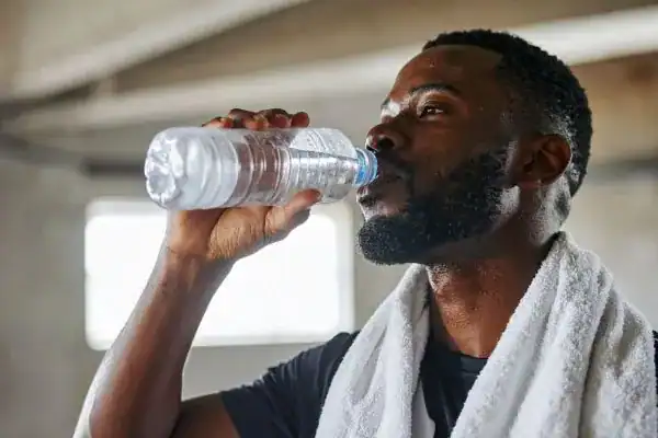 Hydration: The Secret Ingredient for a Toned Stomach and Enhanced Fitness 1 Image of man drinking water to improve hydration Rickmansworth after work out.